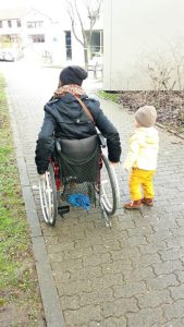 Wheelymum im Rollstuhl mit ihrem Kind daneben